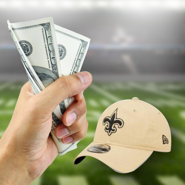 two one-hundred dollar bills in man's hand; new orleans saints baseball hat; football stadium background