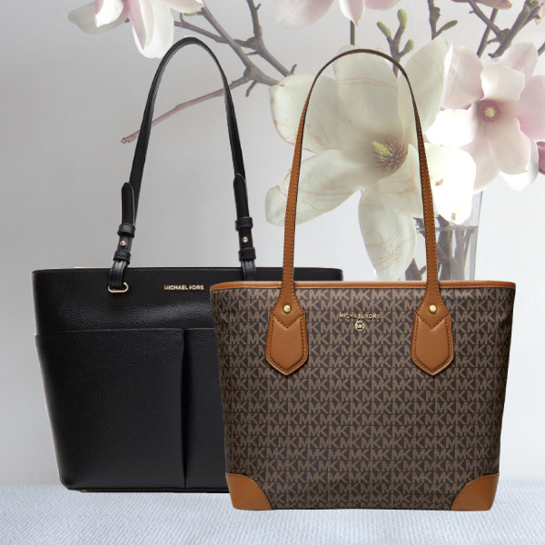 One Black Michael Kors Handbag and One Brown Michael Kors handbag against a white background with white and pink flowers.